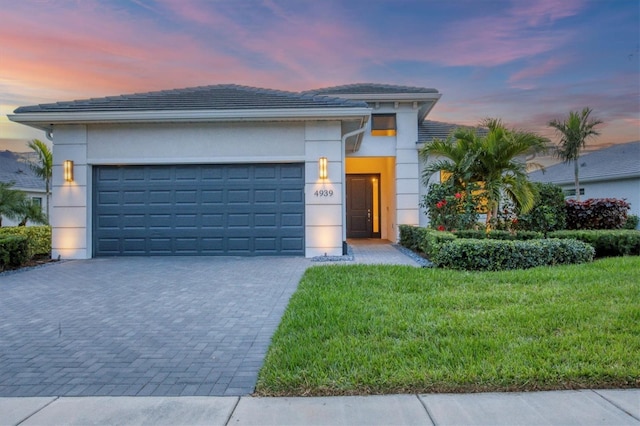 view of front of property featuring a yard and a garage