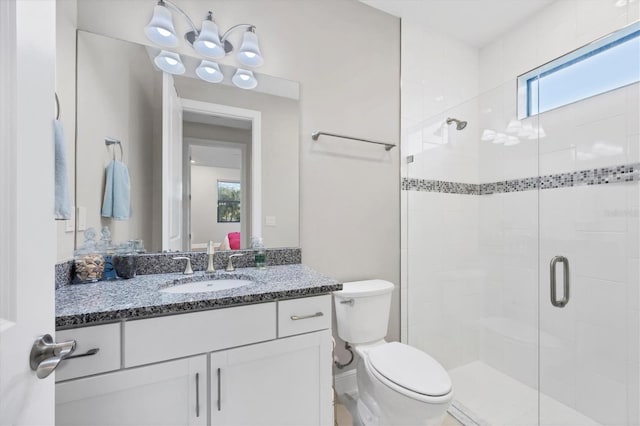 bathroom featuring walk in shower, a wealth of natural light, vanity, and toilet