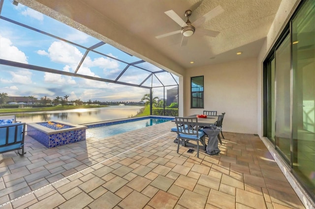 view of swimming pool featuring a patio area, ceiling fan, a water view, and an outdoor fire pit