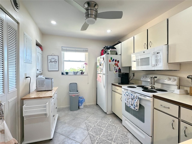 kitchen featuring ceiling fan, stacked washer and dryer, light tile patterned floors, and white appliances