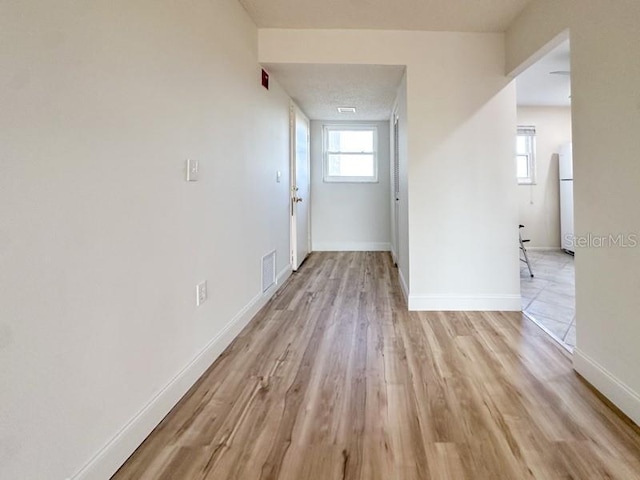 corridor with light wood-type flooring