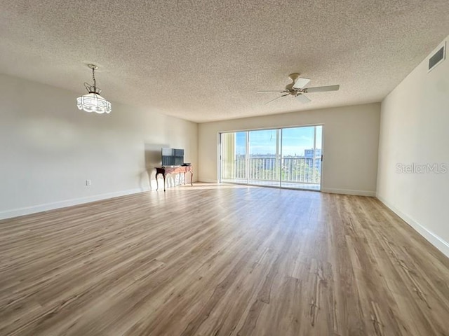 unfurnished living room with ceiling fan, light hardwood / wood-style floors, and a textured ceiling