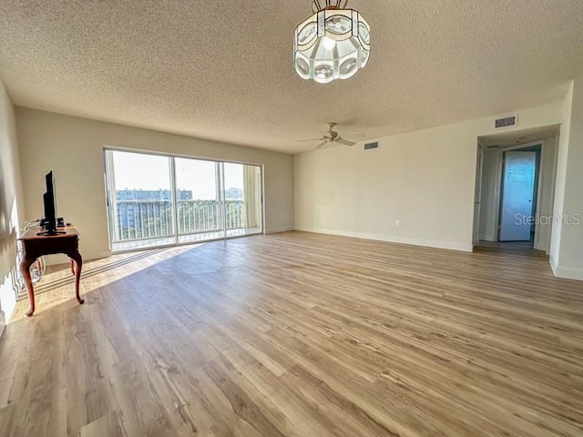 unfurnished living room featuring a textured ceiling, light hardwood / wood-style flooring, and ceiling fan