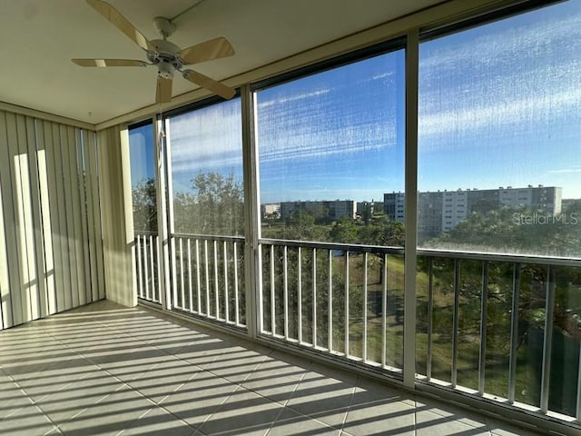 unfurnished sunroom with ceiling fan