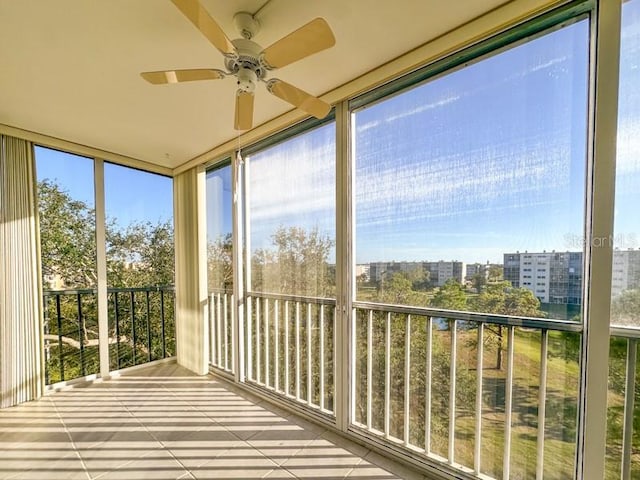 unfurnished sunroom with ceiling fan