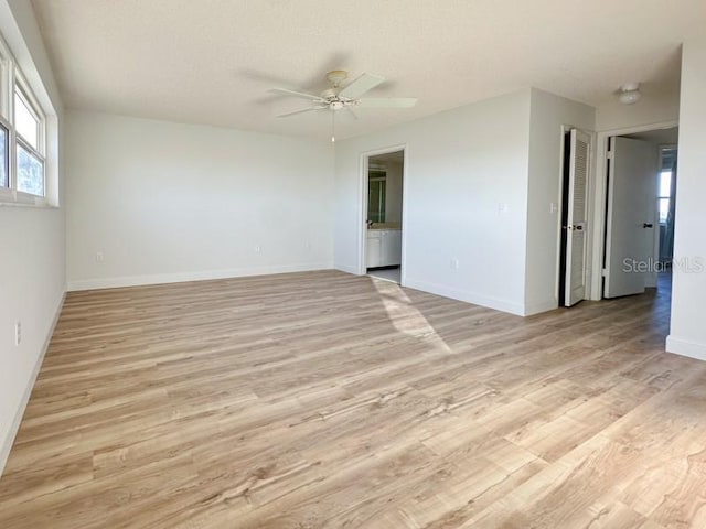 empty room with ceiling fan and light hardwood / wood-style flooring