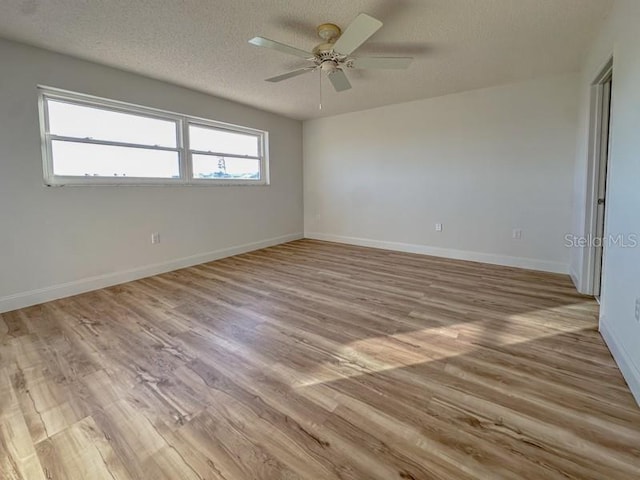 spare room featuring ceiling fan, a textured ceiling, and light wood-type flooring