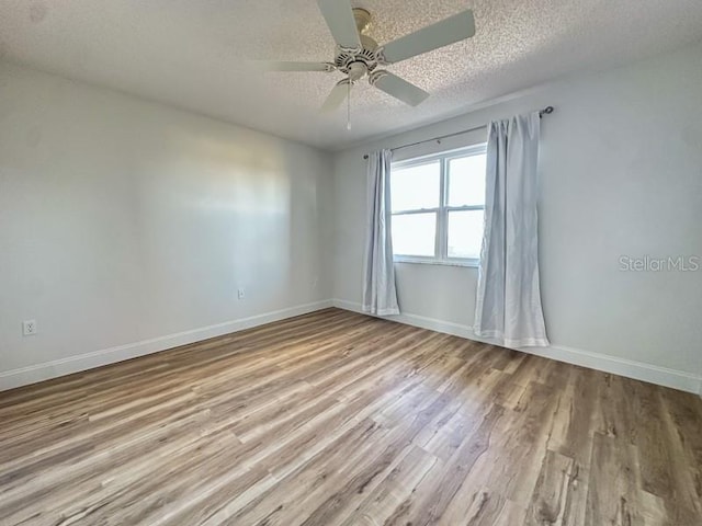 unfurnished room featuring ceiling fan, light hardwood / wood-style floors, and a textured ceiling