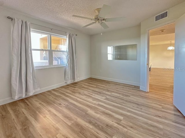 unfurnished room featuring ceiling fan, a textured ceiling, and light wood-type flooring