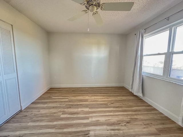 unfurnished room featuring ceiling fan, a textured ceiling, and light hardwood / wood-style flooring