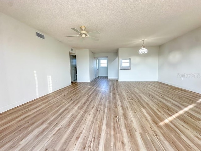 spare room with ceiling fan, light wood-type flooring, and a textured ceiling