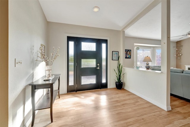 foyer entrance with ceiling fan and light wood-type flooring