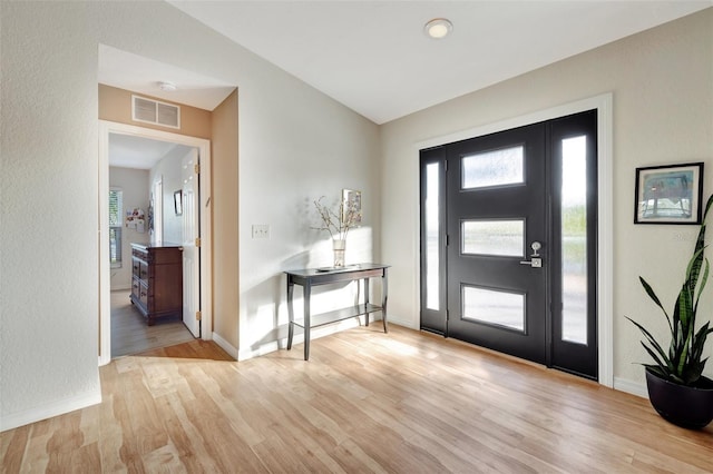 entryway featuring light hardwood / wood-style floors and vaulted ceiling