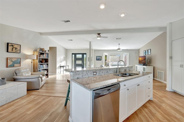 kitchen with dishwasher, sink, lofted ceiling with beams, a center island with sink, and white cabinets