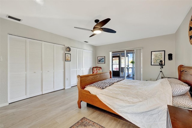 bedroom featuring access to exterior, ceiling fan, light hardwood / wood-style flooring, and multiple closets