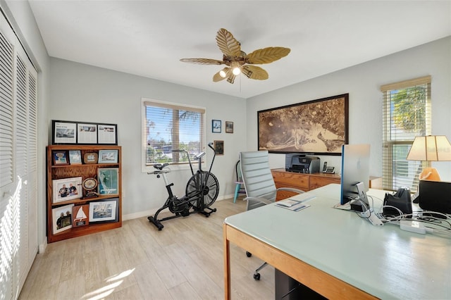 office featuring a healthy amount of sunlight, ceiling fan, and light hardwood / wood-style floors