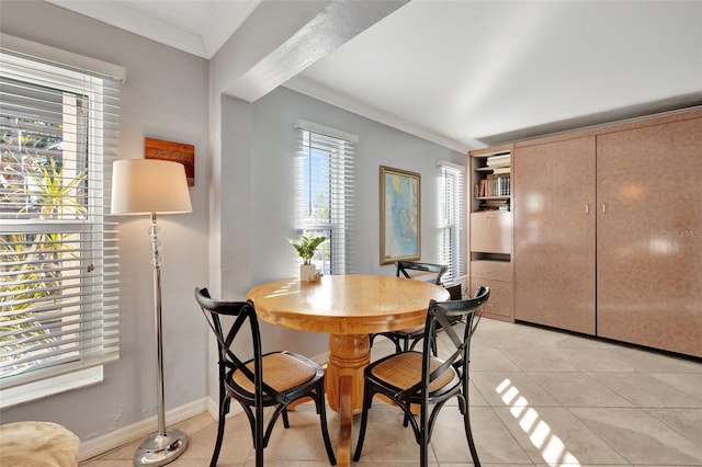 dining room with light tile patterned floors and crown molding