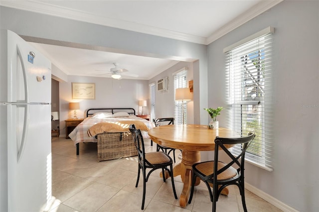 bedroom featuring light tile patterned floors, white fridge, multiple windows, and crown molding