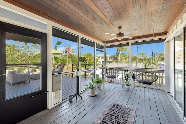 unfurnished sunroom with ceiling fan and wooden ceiling