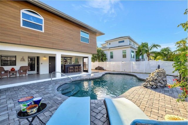 view of swimming pool with exterior bar and a patio