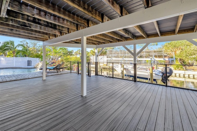 wooden deck with a dock and a swimming pool