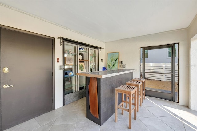 interior space with a kitchen breakfast bar and light tile patterned flooring