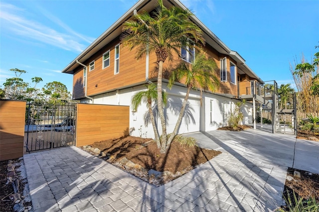521 Cummings St, Sarasota, FL 34242 - view of side of property featuring concrete driveway, a garage, a gate, and stairway