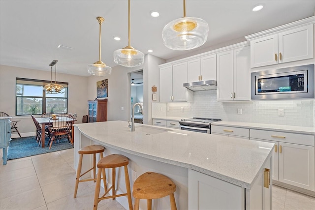 kitchen with appliances with stainless steel finishes, white cabinetry, and hanging light fixtures