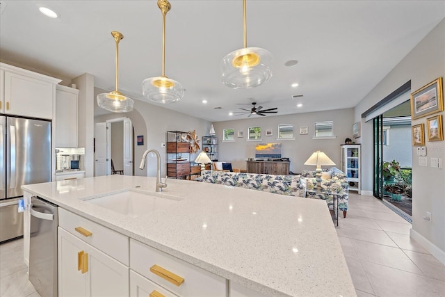 kitchen with light stone countertops, sink, pendant lighting, white cabinets, and appliances with stainless steel finishes