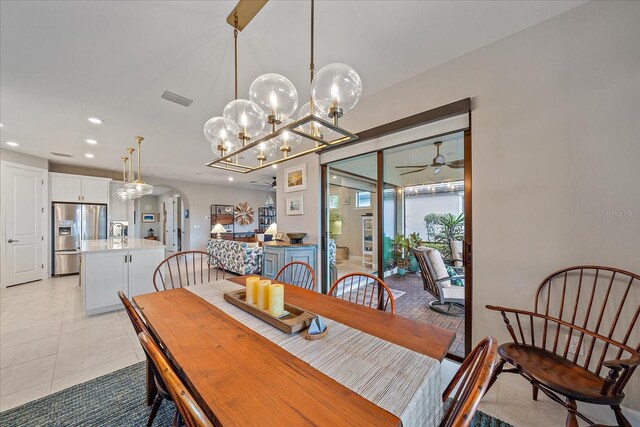 dining room featuring ceiling fan with notable chandelier and light tile patterned floors