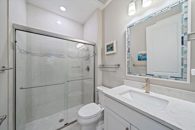 bathroom with a shower with door, vanity, and toilet