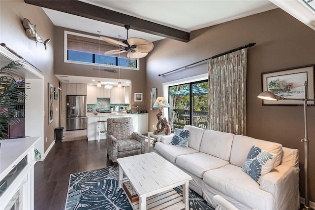 living room with ceiling fan, hardwood / wood-style flooring, beamed ceiling, and a towering ceiling