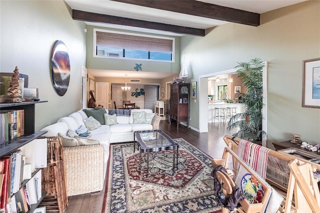 living room featuring dark hardwood / wood-style floors, beamed ceiling, a high ceiling, and a notable chandelier