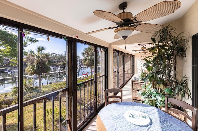 unfurnished sunroom with a water view and ceiling fan