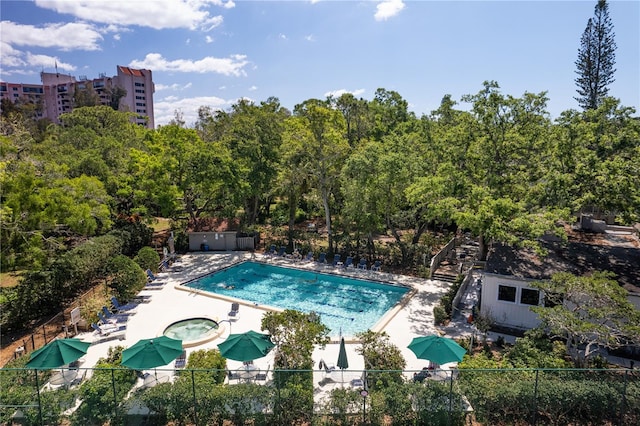 view of swimming pool with a patio area, a community hot tub, and fence