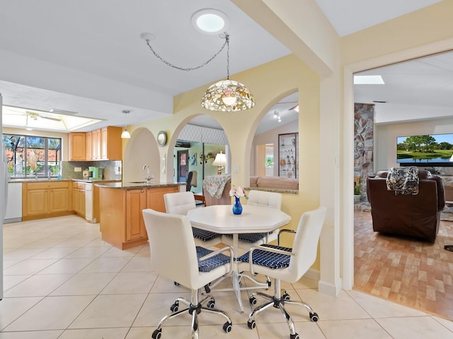 dining room with sink, vaulted ceiling, and light tile patterned flooring