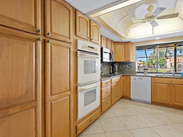 kitchen featuring white appliances, decorative backsplash, ceiling fan, light tile patterned floors, and light stone counters