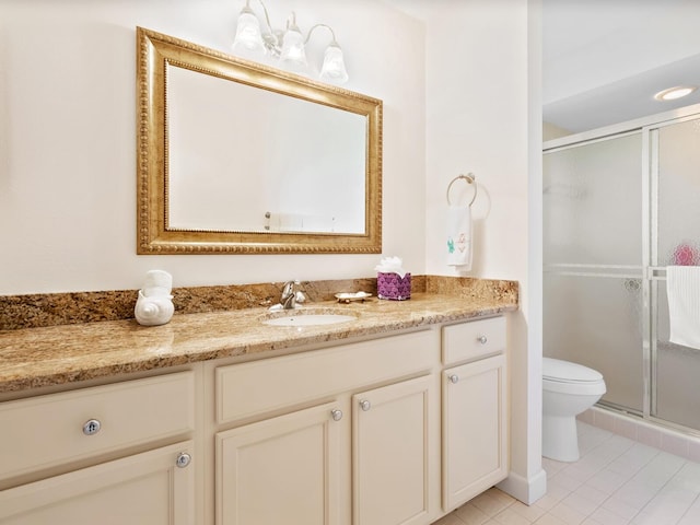 bathroom with tile patterned flooring, vanity, an enclosed shower, and toilet