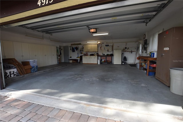 garage with electric panel, white fridge, and a garage door opener