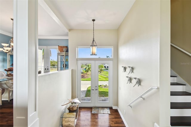 foyer featuring dark hardwood / wood-style floors, ornamental molding, and french doors