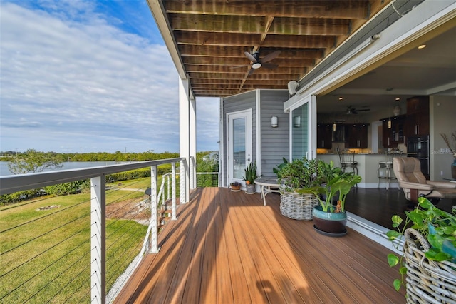 wooden deck with a lawn and ceiling fan