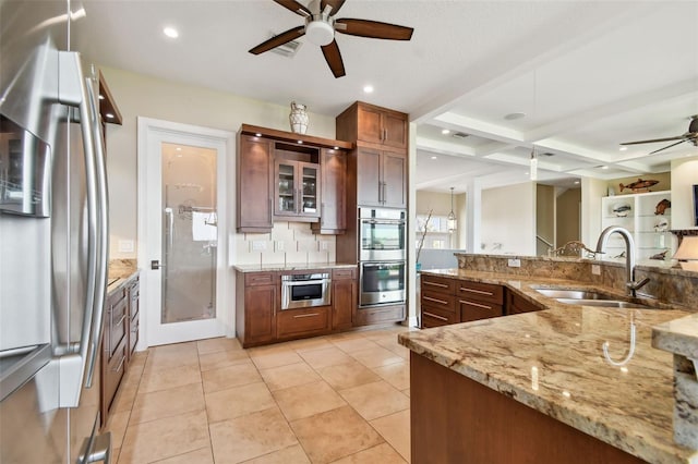 kitchen featuring light stone countertops, appliances with stainless steel finishes, coffered ceiling, sink, and beamed ceiling