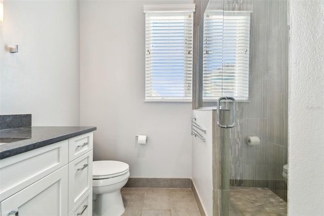 bathroom featuring tile patterned floors, vanity, toilet, and walk in shower