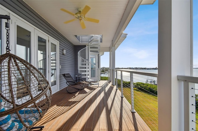 wooden terrace featuring ceiling fan and a water view