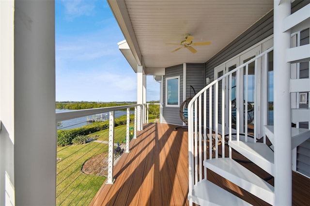 balcony with ceiling fan and a water view