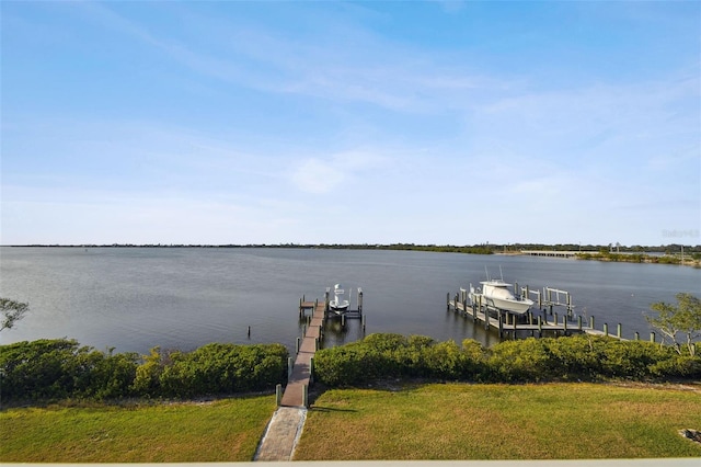 dock area with a lawn and a water view