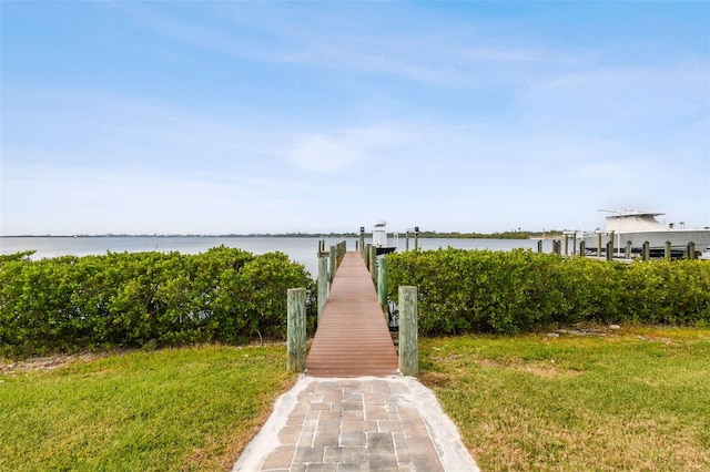 view of dock featuring a water view and a lawn