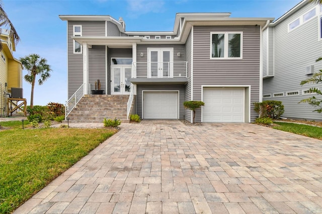 view of front of home with a balcony, cooling unit, a front yard, and a garage