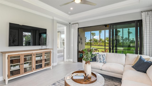 living room featuring a raised ceiling and ornamental molding