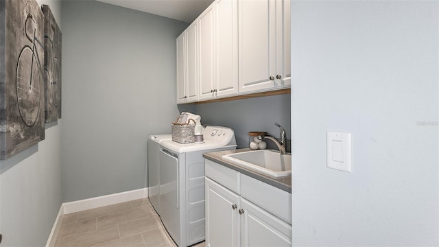 washroom with cabinets, light tile patterned floors, sink, and washing machine and clothes dryer